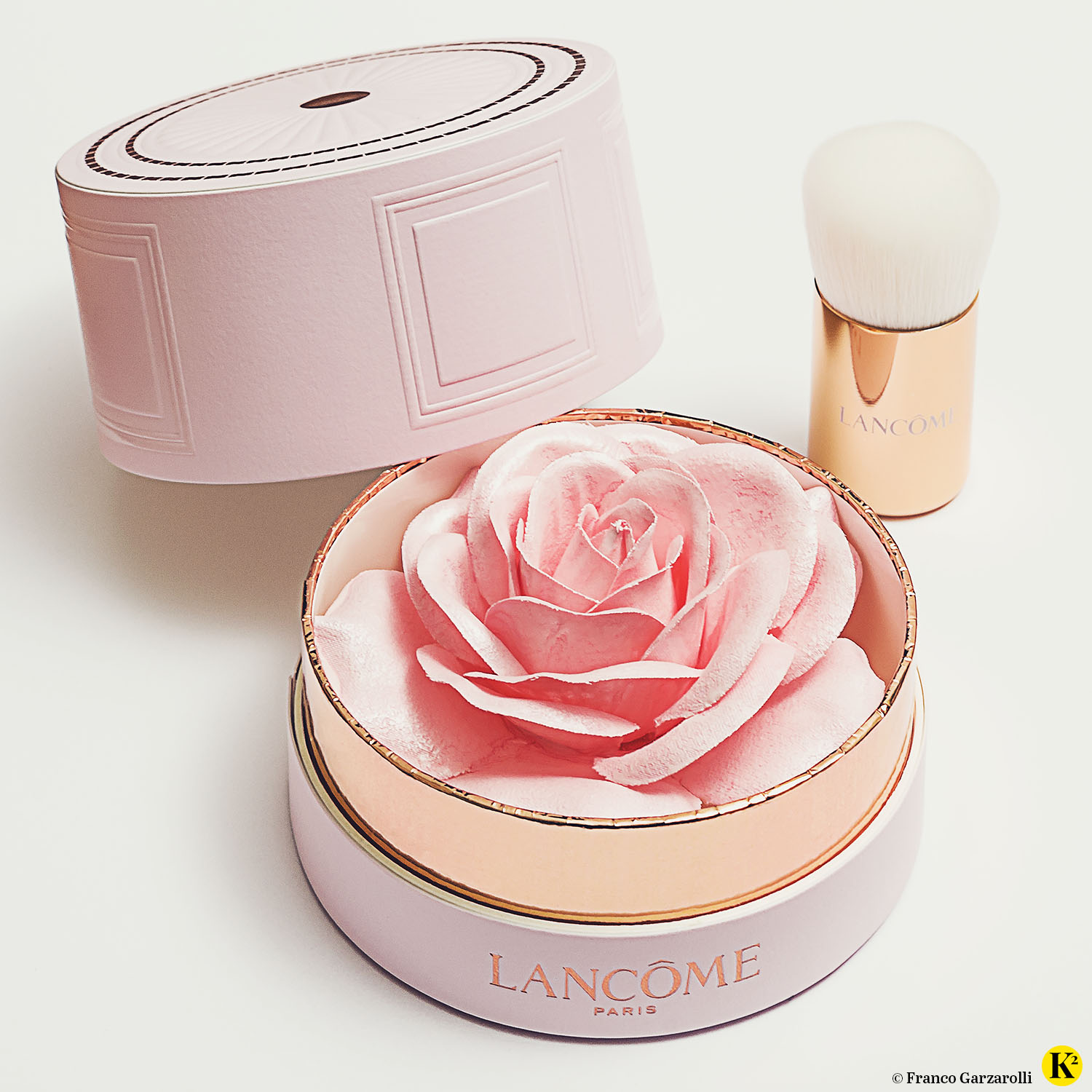 Mit Puder-Highlighter überzogene Stoffrose von Lancome in einer runden Kartonverpackung.
