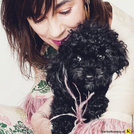 Frau mit schwarzem Toypudel.