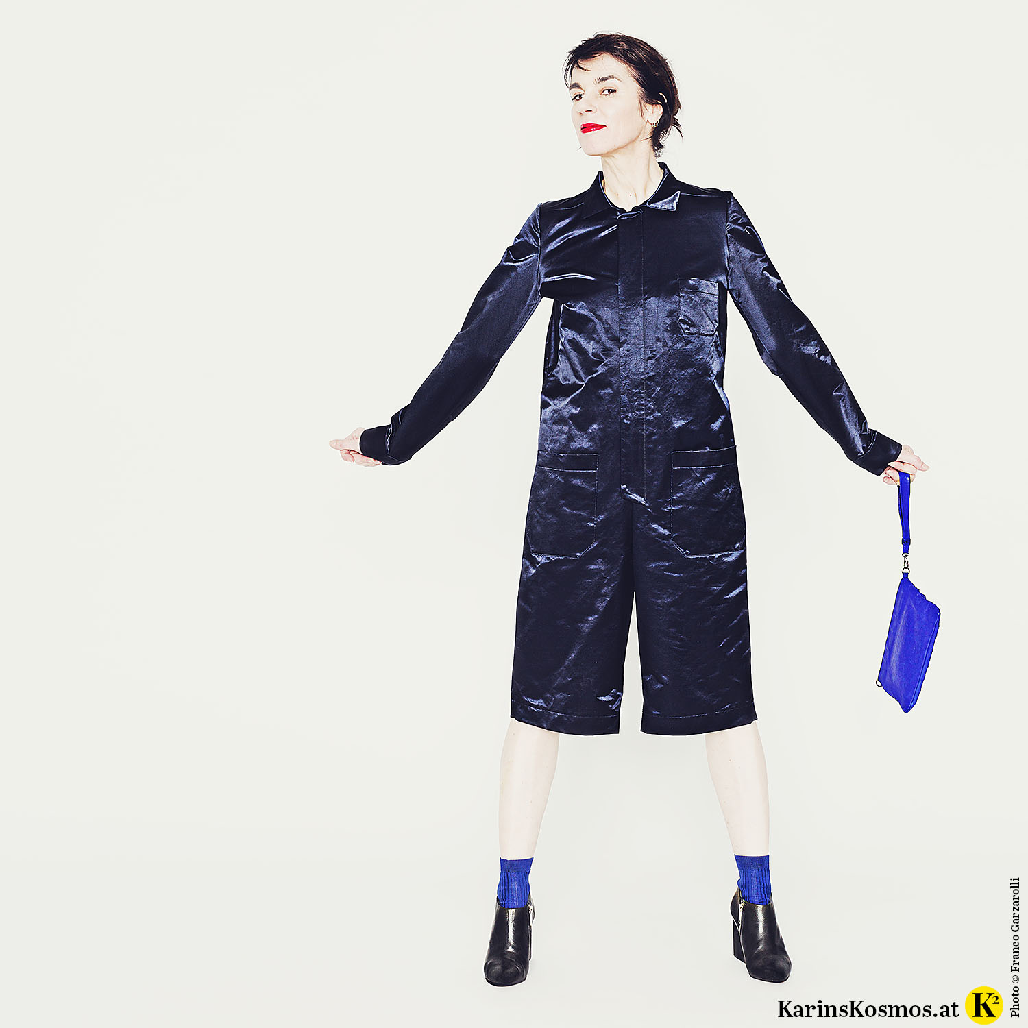 Frau in Overall mit Clutch und Ankle-Boots.
