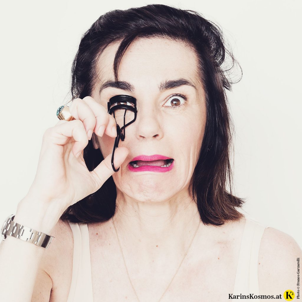 Frau mit leichten Tagesmake-up und einer Wimpernzange.