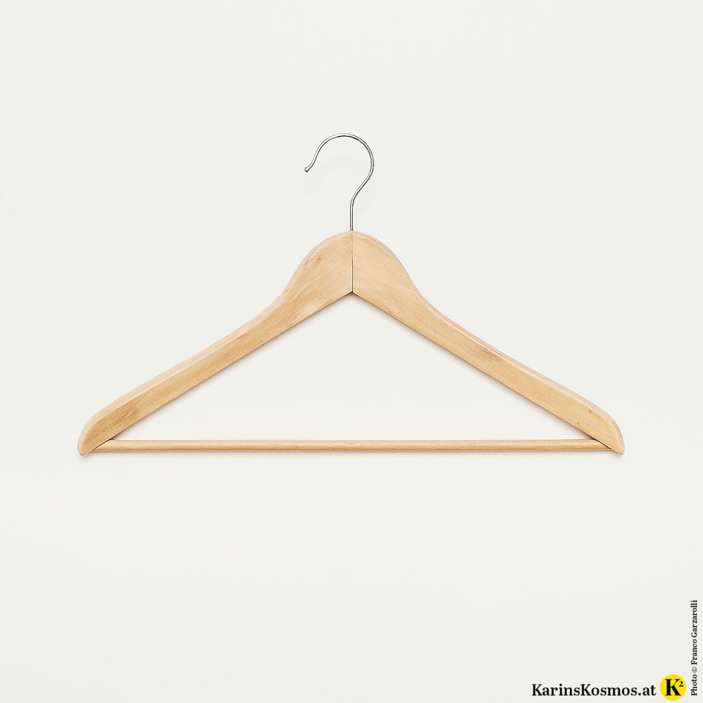 Foto von einem Holzkleiderbügel als Symbol für einen Kleiderschrank.