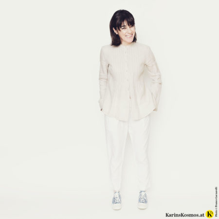 Frau in weisser Hose zu beiger Hose mit Sneakers.