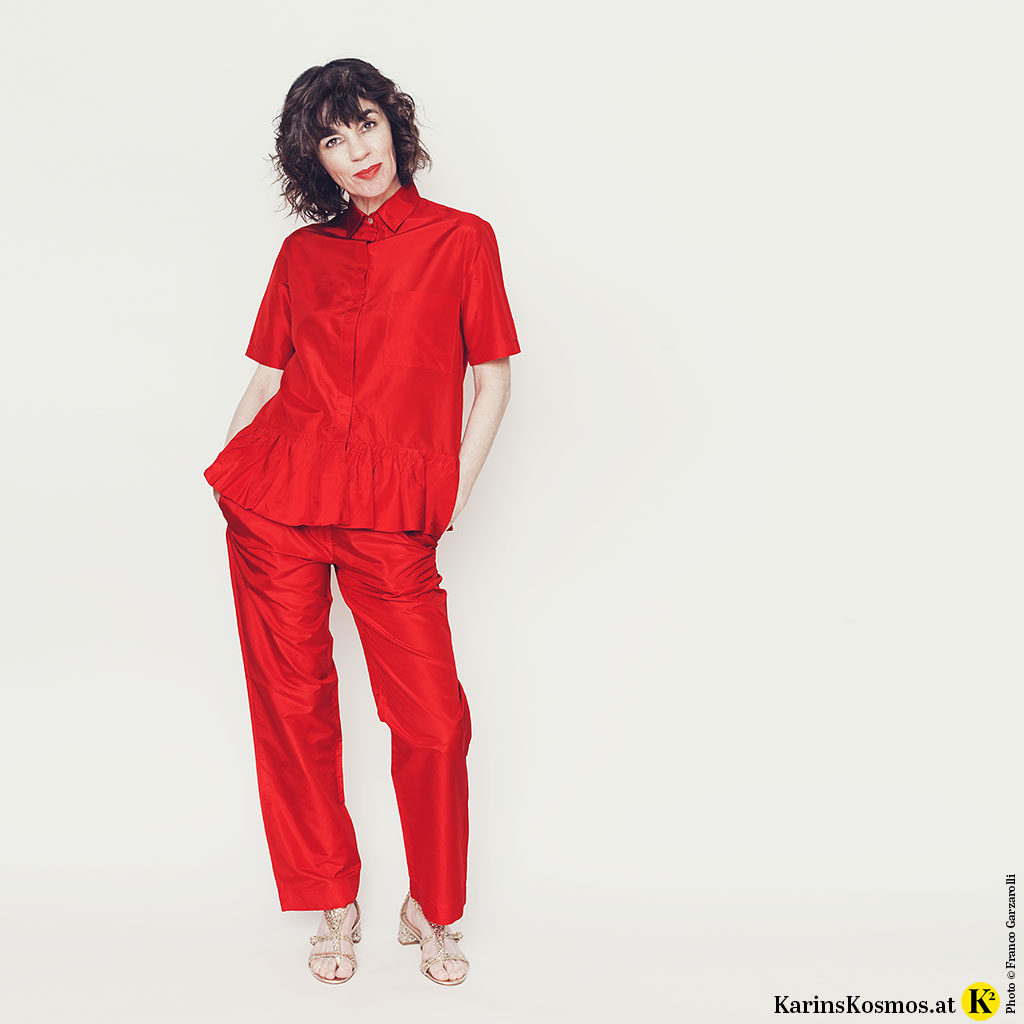 Frau in einem Seidenanzug in Rot.