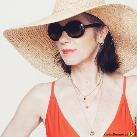 Frua im Badeanzug mit Sonnenbrille und Sonnenht zum Thema Sonnenschutz.