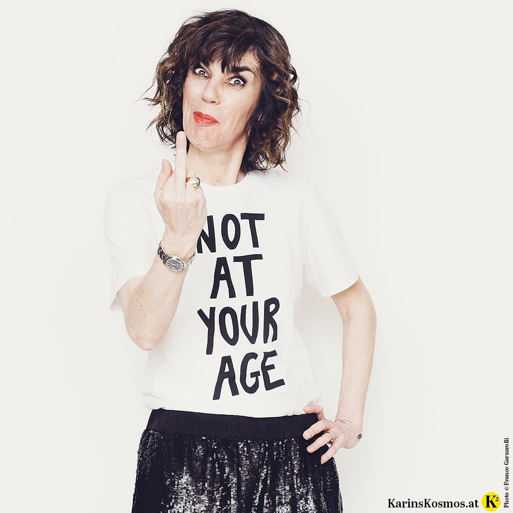 Frau mit Logo-Shirt und dazu Hose mit Pailletten.