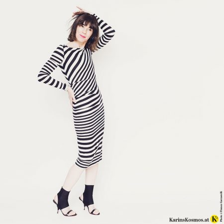 Frau in einem Kleid mit weiß/schwarzen Streifen.