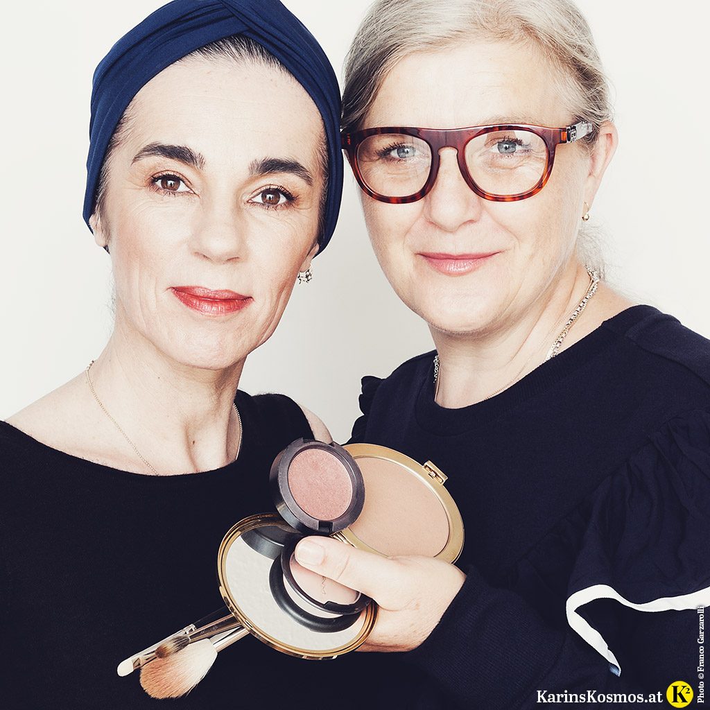 Foto von zwei Frauen. Eine ist Make-up-Artist und hält verschiedene Bronzer und Pinsel in der Hand.