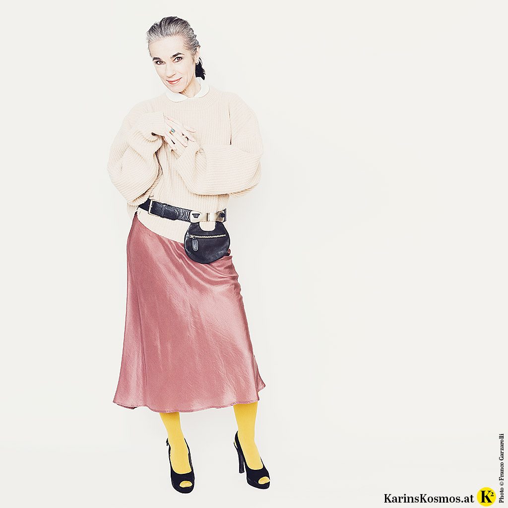 Frau in einem Materialmix aus Samt, Seide & Strick.