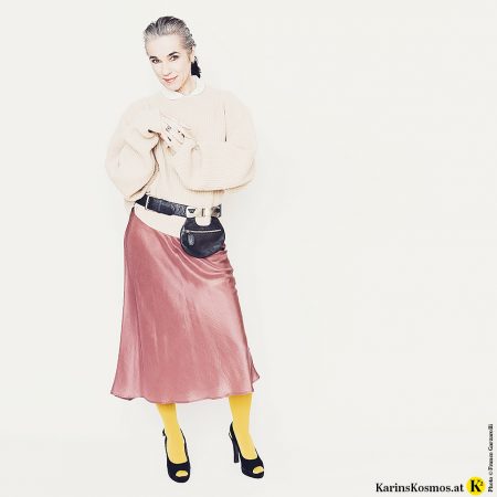 Frau in einem Materialmix aus Samt, Seide & Strick.