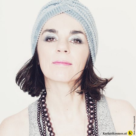 Frau mit Samtturban, Perlenkette und modernem 20er-Jahre Make-up.