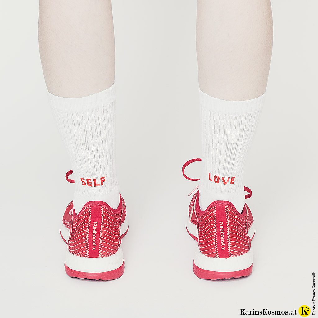 Frau mit Turnschuhen an und Socken mit der Aufschrift "Self Love". Es geht hier um stop smoking.