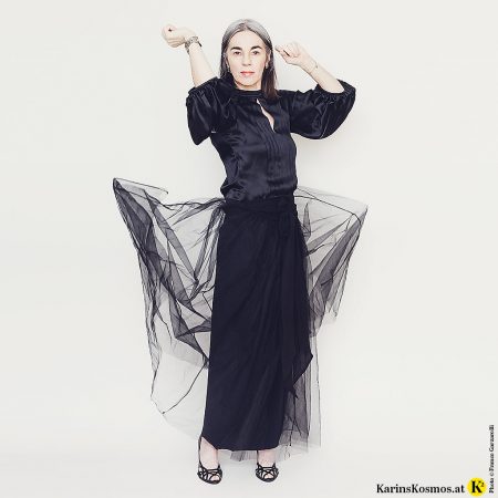 Frau in schwarzer Seidenbluse und schwarzem Tüllrock.