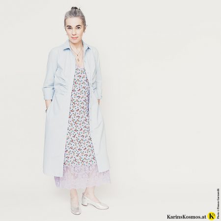 Frau in einem Hemdblusenkleid über einem Slipdress als Mantel getragen.