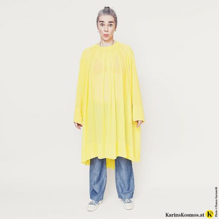 Karin Garzarolli von Karins Kosmos in Flared Jeans mit gelbem Kleid dazu.